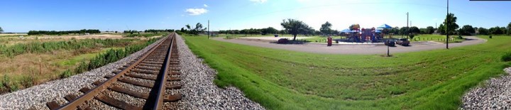 A panoramic view of the railroad tracks dividing the park from the slab where the fertilizer plant once stood.