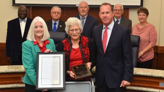 Photo courtesy of Blinn College. Front row (L-R) chancellor Mary Hensley, Teddy Boehm, and trustees chairman Jim Kolkhorst. Rear row (L-R) Trustee members Randy Wells, Douglas Borchardt, Dennis Crowson, Charles Moser, and Allison Bentke.