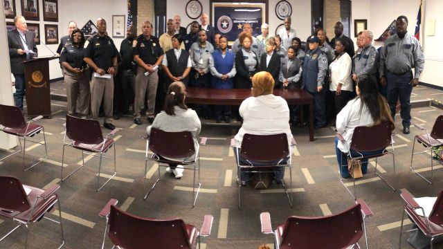 Panoramic photo of corrections officers and employees receiving a proclamation from Brazos County commissioners on April 26, 2022.