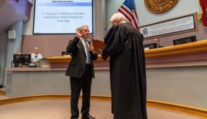 Photo from the city of Bryan of (L) James Edge being sworn in as single member district four councilman by (R) Texas 10th district court of appeals justice Steve Smith.