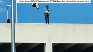 Photo taken by a WTAW listener. WTAW News blurred the face of the person. To the left of the person, left of what is a flagpole, is one of two Bryan police officers at the top of the downtown Bryan parking garage.