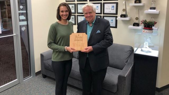(L-R) Destination Bryan community engagement manager Katelyn Brown and Bryan Broadcasting vice president Ben Downs holding the award from the Texas Downtown Association, November 8 2022.