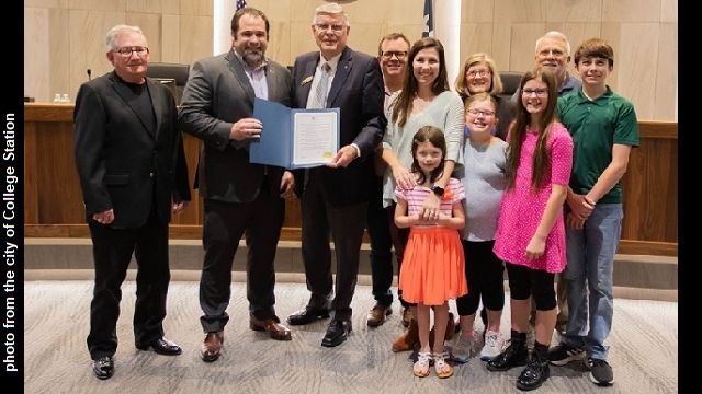 Photo from the city of College Station where a proclamation is held by (L-R) A&M United Methodist Church senior pastor Preston Greenwaldt and College Station mayor John Nichols.