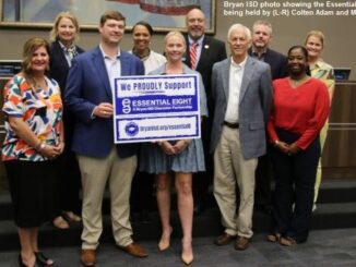 Bryan ISD photo taken September 25, 2023, showing Adam Foundation representatives (L-R) Colten Adam and Madison Januse holding a BISD "Essential Eight" sign.