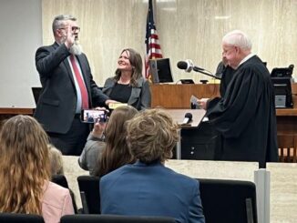 (L-R) Jerrell Wise takes the oath of office as the first judge of Brazos County's 472nd district court, while his wife Emily holds the Bible and justice Steve Smith of the Texas 10th court of appeals administers the oath.