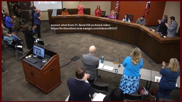 Screen shot of the December 4, 2023 Fort Bend ISD school board meeting, with Christie Whitbeck (sitting in front of the U.S. flag) receiving a standing ovation. Screen shot is from https://fortbendisd.new.swagit.com/videos/283337
