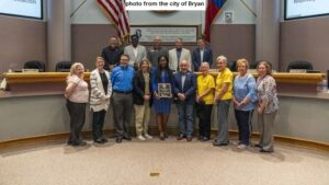 Photo from the city of Bryan. The award plaque is held by B/CS library director Bea Saba.