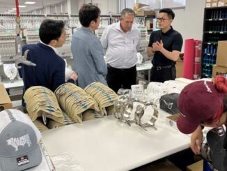 At the far right, Tajima Industries CEO Hidetoshi Kojima visits with C.C. Creations owner Kenny Lawson during a tour of Tajima embroidery machines in operations at the new C.C. Creations Legacy Campus in Bryan TX on June 28, 2024.