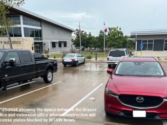 Photo taken 7/25/2024 showing the space between the Brazos County tax office and extension office where construction will take place. License plates blocked by WTAW News.