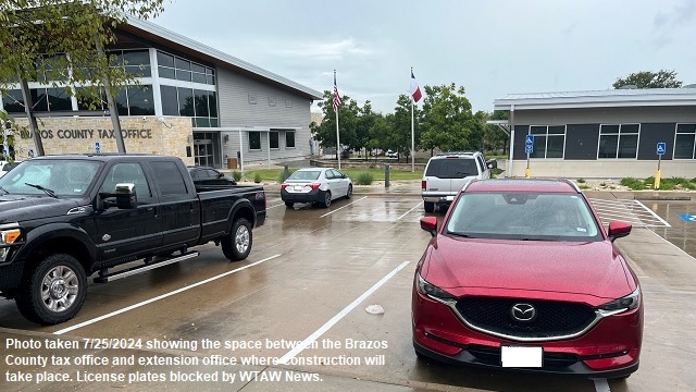 Photo taken 7/25/2024 showing the space between the Brazos County tax office and extension office where construction will take place. License plates blocked by WTAW News.