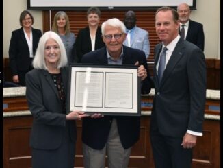 Blinn College photo showing Charles Moser (center) receiving a framed copy of a resolution from (L) chancellor Mary Hensley and (R) trustees chairman Jim Kolkhorst.