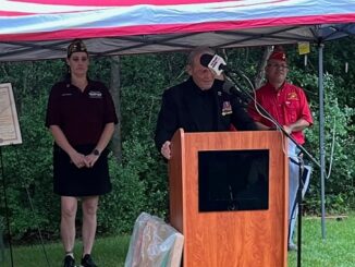 Roy May Sr. speaking at the 2025 Memorial Day program. Behind him are College Station VFW post 12221 commander Heather Huhnke and Roger Martinez of the Marine Corps League detachment 3291.