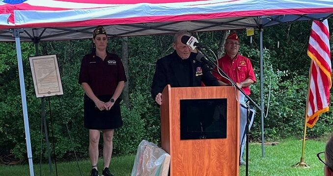 Roy May Sr. speaking at the 2025 Memorial Day program. Behind him are College Station VFW post 12221 commander Heather Huhnke and Roger Martinez of the Marine Corps League detachment 3291.